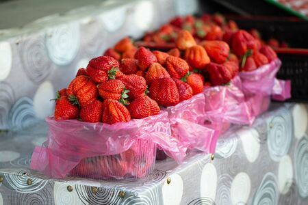 Ripe strawberries lies in trays, a slide counter, in the marketの写真素材
