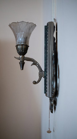 An old bronze sconce with a rope hangs on the wall. Vertically.の写真素材