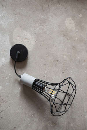 loft chandelier with led light bulb, lying on the gray concrete floor.の写真素材