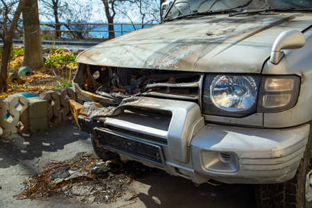 There is a burned-out  in the street parking near the sea.の写真素材