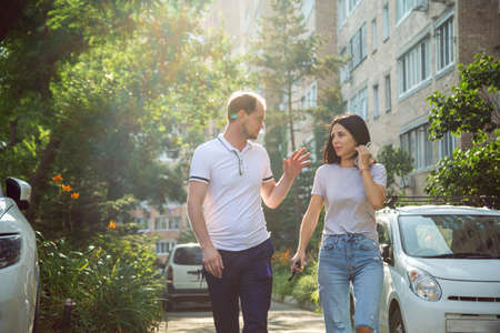 Young people, Millennials, walking down a city street in summer clothes and talking passionately.の写真素材
