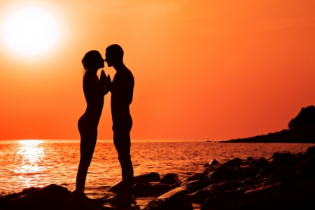 The loving couple on a decline, the sea, shines the sunの写真素材