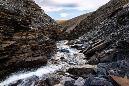 The anonymous brook weeping from mountains on Northern island of archipelago Novaya Zemlyaの写真素材