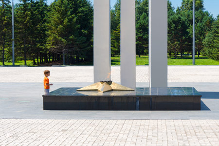 The boy examines the memorial complex devoted to inhabitants Komsomolsk-na-Amure, the victim during the Second World War.のeditorial素材