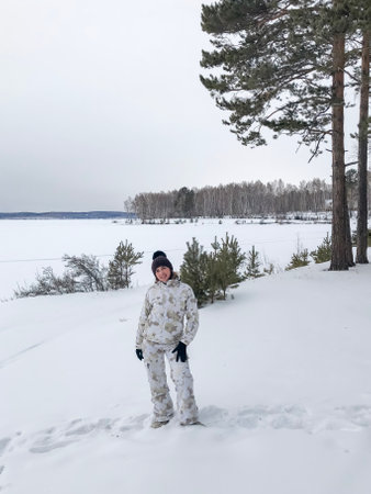 Young smiling woman enjoys snowy winter day.の写真素材
