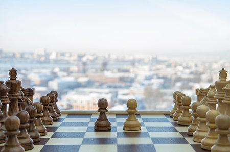 Chess battle. Two chess armies on the wooden chessboard. Empty place for text.