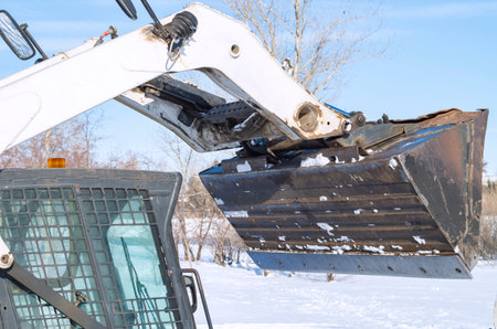 Bulldozer snow removal, close-up of excavator bucket cleaning the road for the machine
