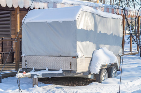 Motorhome RV, trailer, campervan parked near house under snow in winter.の写真素材