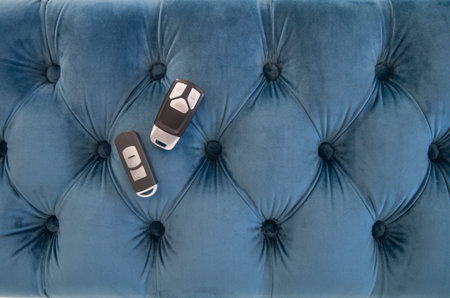 Car keys on a blue velvet background. Close-up of black keys from a modern car, buyer selects a new...