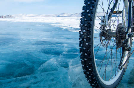 Bicycle on ice. Close-up of a studded bicycle tire on the background of an icy surface. Winter sport conceptの写真素材