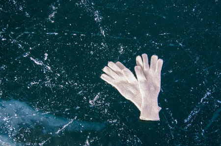 White gloves lie on the ice of frozen Lake Baikal. Winter vacation and travel concept.