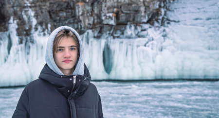 Portrait Of Young Smiling Teen Boy In winter on Lake Baikal. Dream, freedom and travel concept.の写真素材
