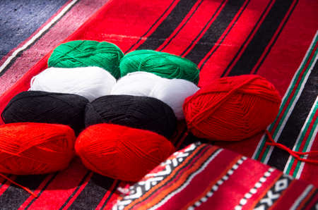 ?omposition of colored balls of fabric for knitting a traditional Arabic carpet in the color of the flag of the UAE.の写真素材