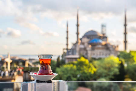 Hot black Turkish tea. Cups of Turkish tea with a saucer against the backdrop of the Hagia Sophia at dawn.の写真素材