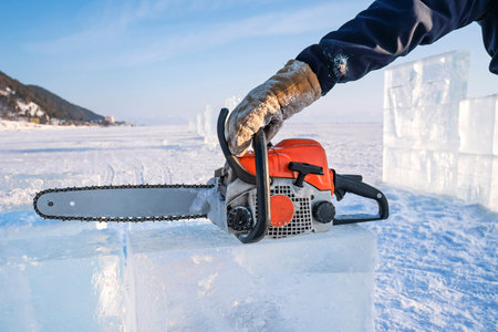 Making ice sculptures. A man holds a gasoline saw on Lake Baikal.