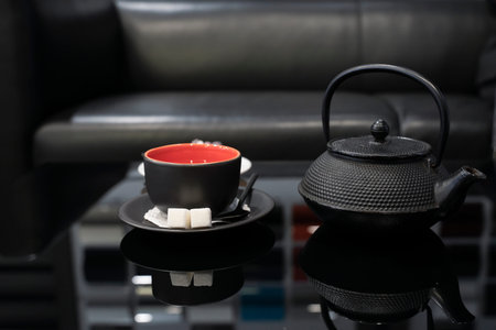Tea pair and teapot on a black glass table. Close-up.の写真素材