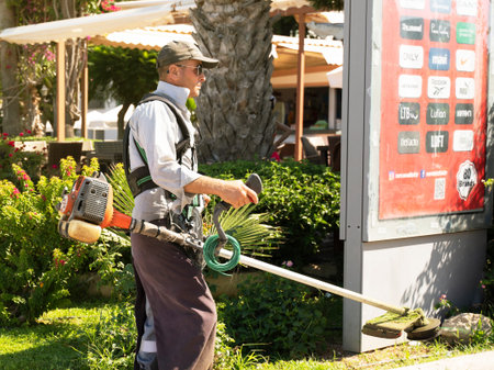 Turkey, Side. July 28, 2022. Gardener with a manual lawn mower. Lawn mowing with a lawn mower.