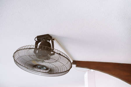 Fan with blades in a protective casing on the ceilingの写真素材