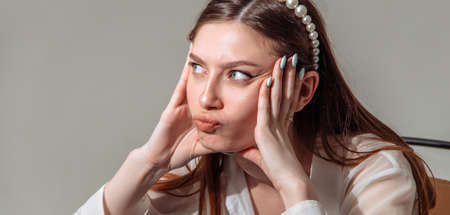 Beautiful model puffed out her cheeks. Portrait of a young strict woman.の写真素材