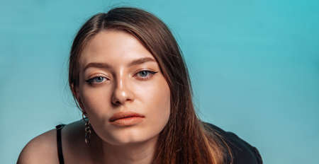 Portrait of a beautiful woman with clean face on blue background.の写真素材
