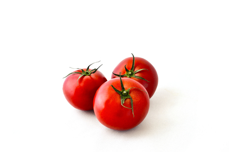 Red delicious tomatoes with green sprigの写真素材