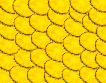 Background assembled from round slices of sliced Golden-colored bright pineapple for design and creativityの写真素材