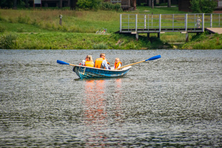 A large family resting on the pond of the river riding on a rowing boat number one