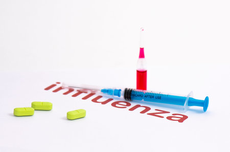 A syringe for injecting medicine intended for covid 19 disease coronavirus and ampoules with a solution of flu medicationの写真素材