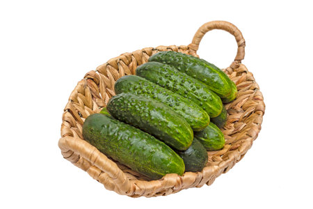 Fresh cucumbers in basket on wood,cucumbers in a basket,ripe vegetables,white backgroundの写真素材