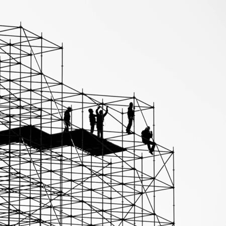 Five construction workers building a metallic scaffoldの写真素材