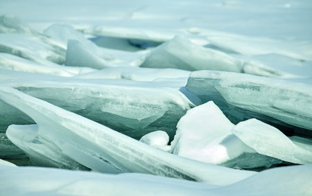 thick ice pieces in the ice close up in the winter thaw with puddles on iceの写真素材