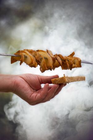 Barbeque sticks with meat, on the grill and heavy smoke above brazier.の写真素材