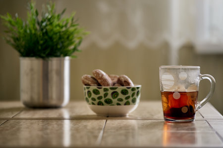 Close up picture of tea in transparent cup with biscuit cookies on a cotton napkin isolated on white backgroundの写真素材