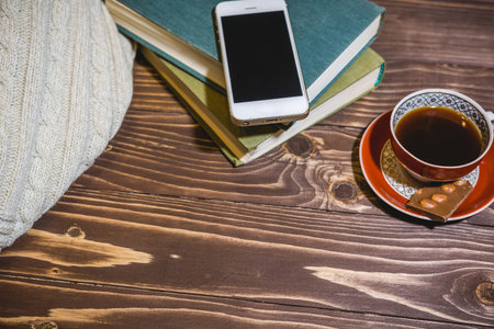 The girl reads the book and has coffee. Rest and reading house. Read to a hobby books.