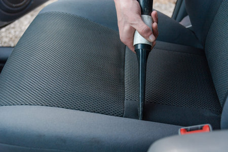 The man vacuums in a passenger compartment. The young man tides up the car.の写真素材
