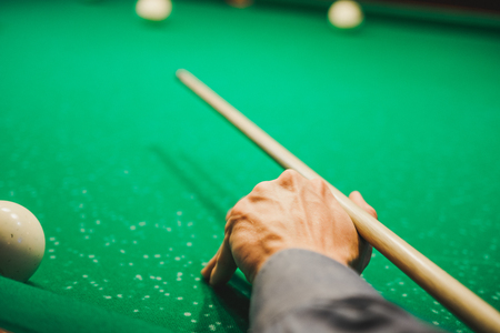 To play billiards. The man plays billiards. Desktop gambling. To hit into a sphere.の写真素材