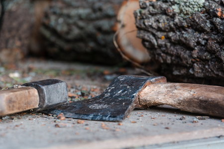 Axe and firewood. The axe lies near firewood. The axe for splitting of a tree.の写真素材