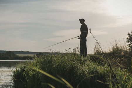 Fishing. The fisherman with a rod. Kontrova light. The man fishes.の写真素材