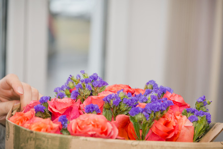 The girl the florist makes a bouquet of flowers. The florist does a bouquet. Paper for flowers.の写真素材