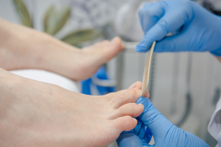 Do to the girl in salon a pedicure. A pedicure in beauty shop. Beautiful nails standing.の写真素材