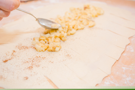 Girl with her hands makes an apple pie with a delicious juicy fillingの写真素材