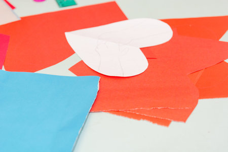 Multicolored cardboard on the table. A heart cut from cardboard from paper. Paper heart.