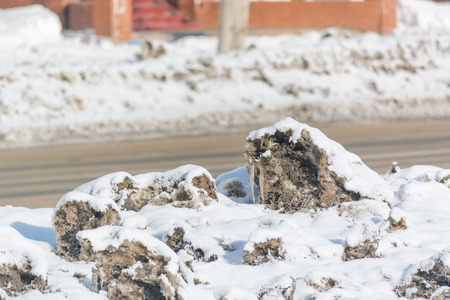 Dirty snow is melting. Snow is thrown by the road. The sun is drowning the snow. Mud in the winter on the road.の写真素材