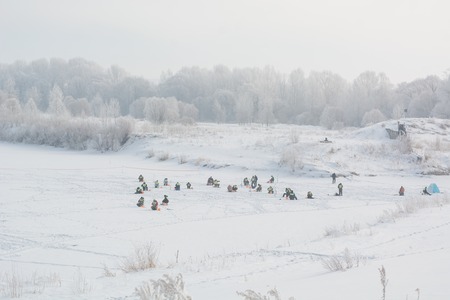 A lot of fishermen for winter fishing. Competitions for winter fishing. View from afar to fishermen in winter.の写真素材