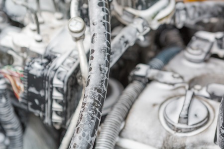 Wash the engine with foam. The engine is in the foam for washing the car. Hoses in the foam. Car wash.の写真素材