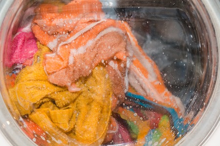 The machine washes clothes. Washer for billi. Clothes in the washing machine drum. Washing machine.の写真素材