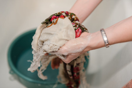 Handwash. A woman is washing her hands. Washing clothes. Wet clothes.の写真素材