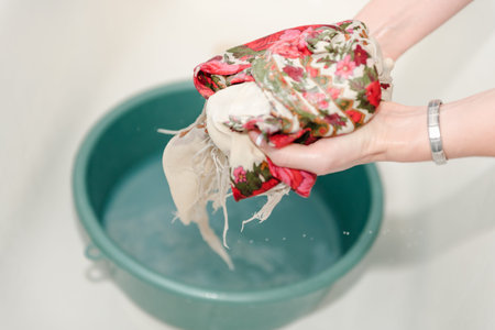 Handwash. A woman is washing her hands. Washing clothes. Wet clothes.の写真素材