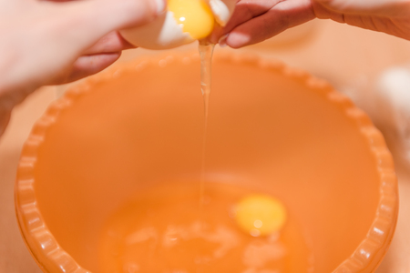 The girl breaks the egg. Cooking homemade food. Eggs for the test. Cooking dough. Natural food. Home cooking. Cooking.の写真素材