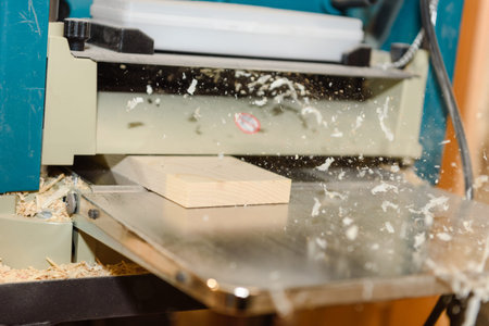 Wood processing on the machine. Flies shavings. Level the board. Joiner's tool. Home workshop.